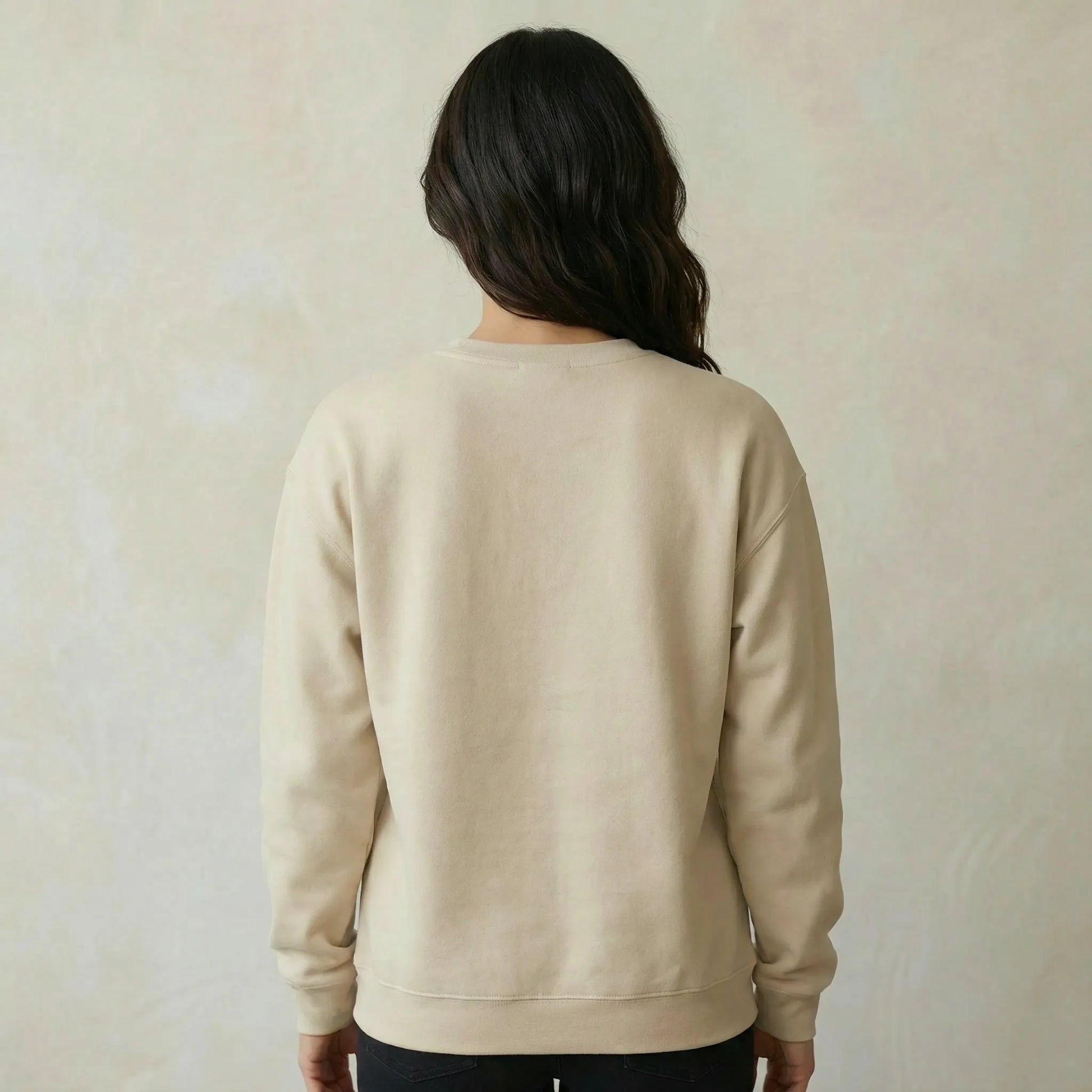 Person wearing a beige sweatshirt against a plain background