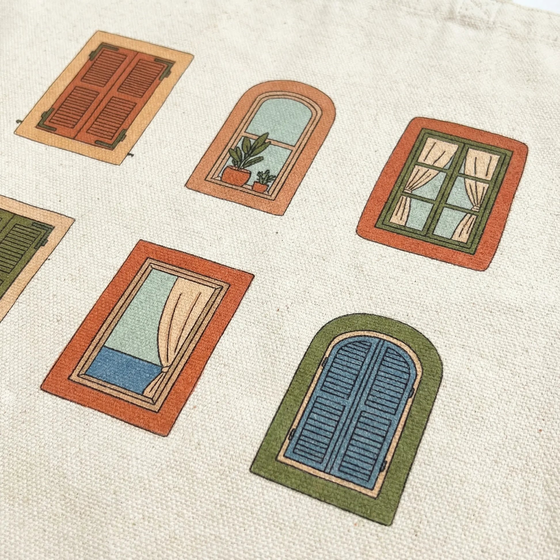 Close-up of six illustrated Mediterranean windows printed on natural cotton tote fabric.