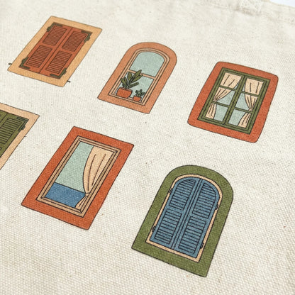 Close-up of six illustrated Mediterranean windows printed on natural cotton tote fabric.