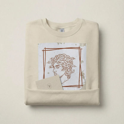 Folded Sand Minimal Medusa sweatshirt with artwork visible in a minimal brand scene