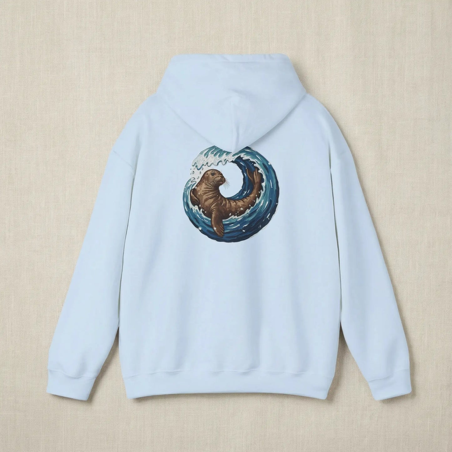 Flat lay of Monk Seal Embrace hoodie showing full back monk seal and wave print