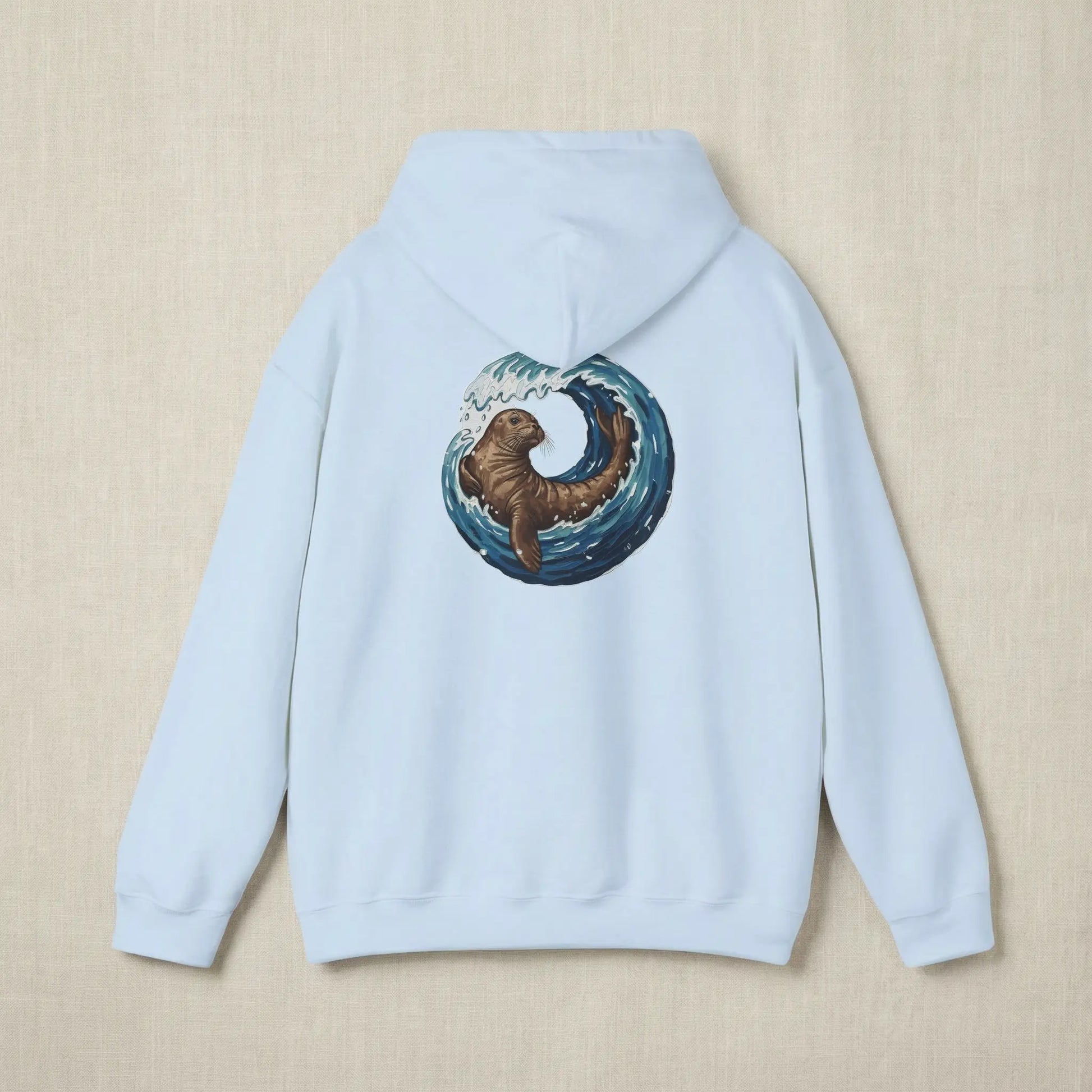 Flat lay of Monk Seal Embrace hoodie showing full back monk seal and wave print