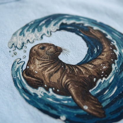 Close-up of monk seal and wave DTG print on Monk Seal Embrace hoodie fabric