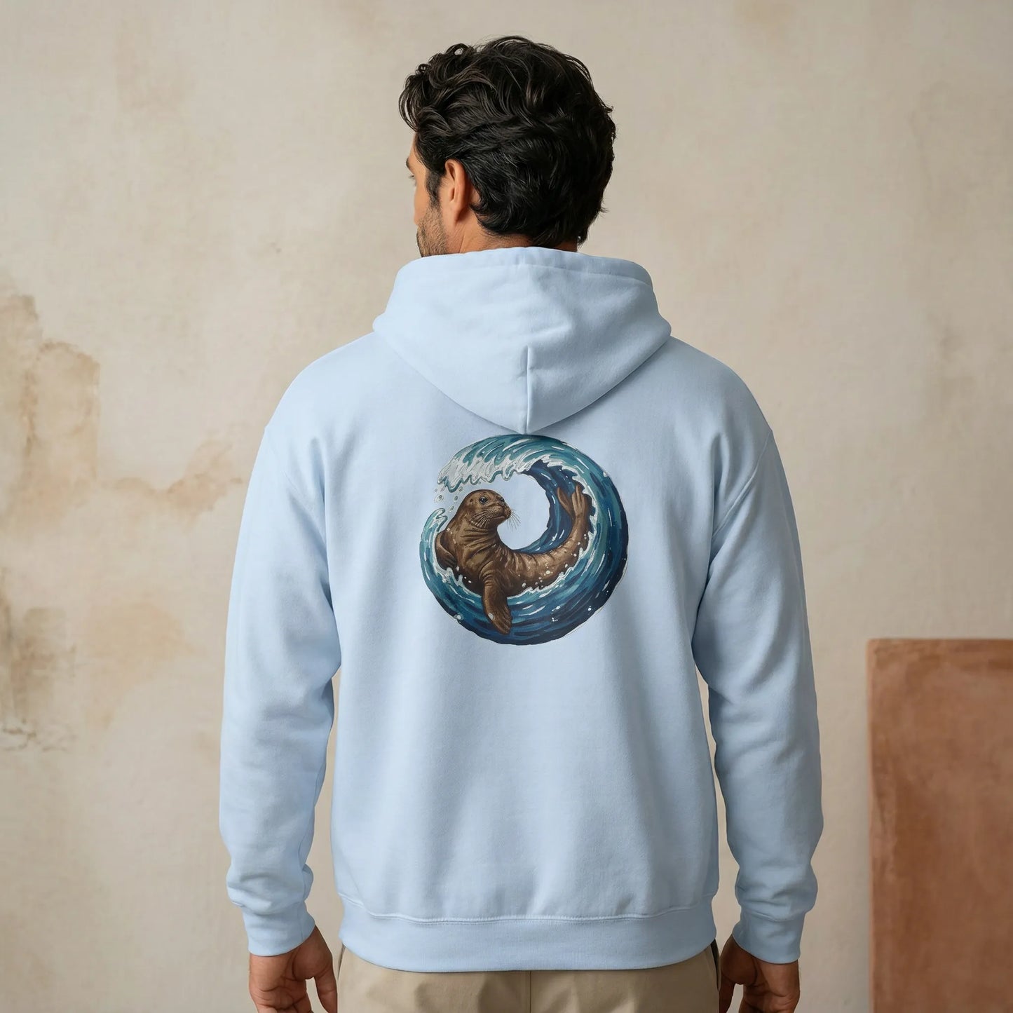 Back view of Monk Seal Embrace unisex hoodie showing monk seal and wave ocean conservation design