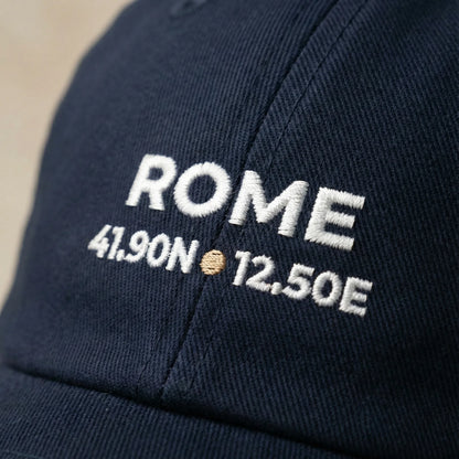 Navy blue cap with 'ROME' and coordinates embroidered on it.