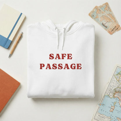Folded Safe Passage hoodie with embroidered slogan and minimal travel and solidarity props