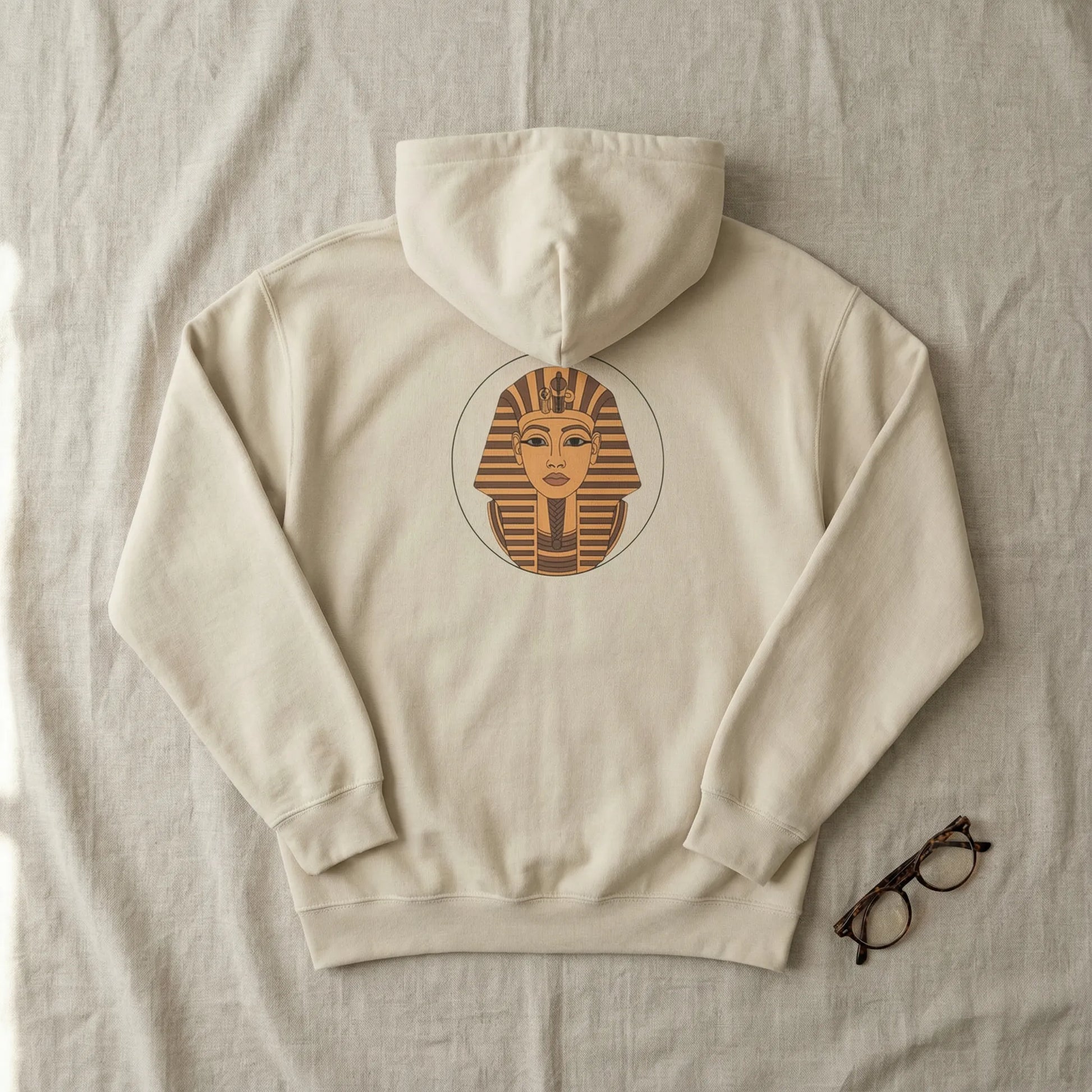 Flat lay of sand Sphinx graphic hoodie showing centred back Sphinx badge on neutral background