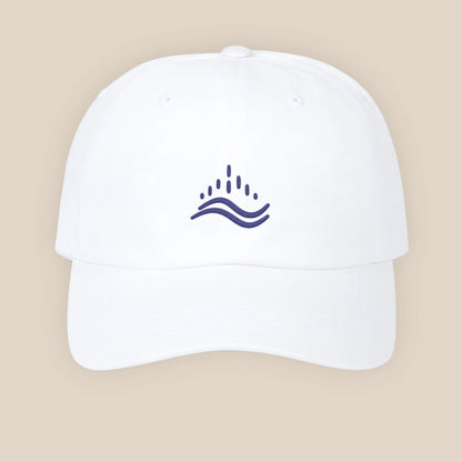 White embroidered dad cap, navy wave emblem, adjustable strap, clean studio set.