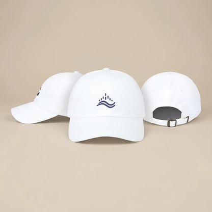 White embroidered dad cap shown in three angles (front, side, back), navy wave emblem, adjustable strap, clean studio set.