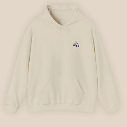 Sand unisex hoodie with small navy waves emblem embroidered on the left chest, photographed front view in a beige background