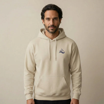 TP:HERO Studio front view of a model wearing the sand Waves Emblem Hoodie with a small navy waves emblem embroidered on the left chest.