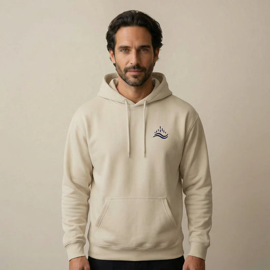 TP:HERO Studio front view of a model wearing the sand Waves Emblem Hoodie with a small navy waves emblem embroidered on the left chest.