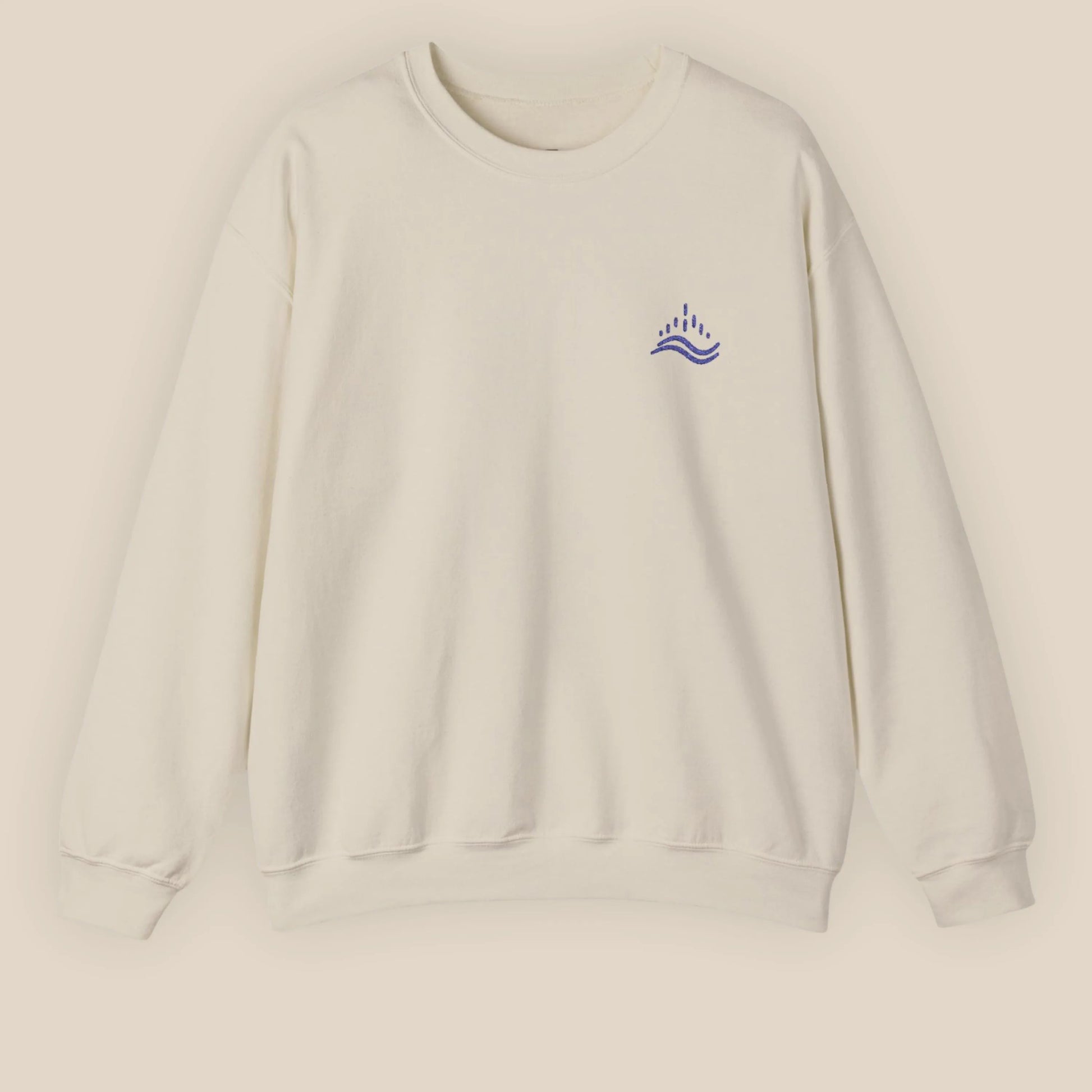 Sand unisex sweatshirt with navy waves emblem embroidered on the left chest, photographed flat in a neutral studio.