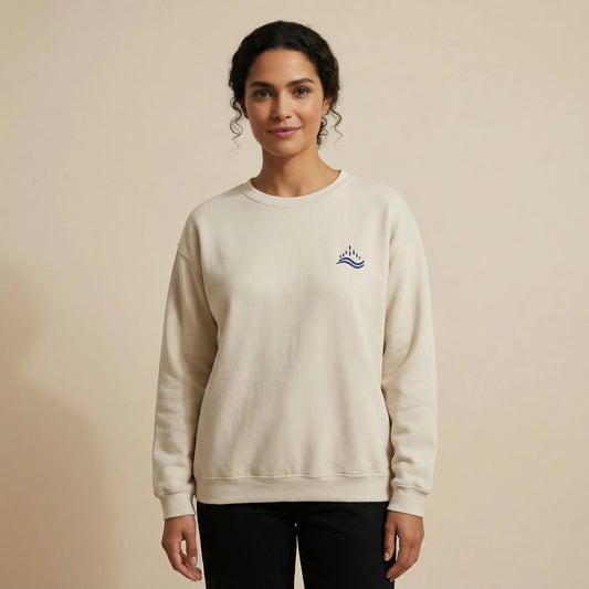 TP:HERO Studio front view of a model wearing the sand Waves Emblem Sweatshirt with a navy left-chest embroidery.