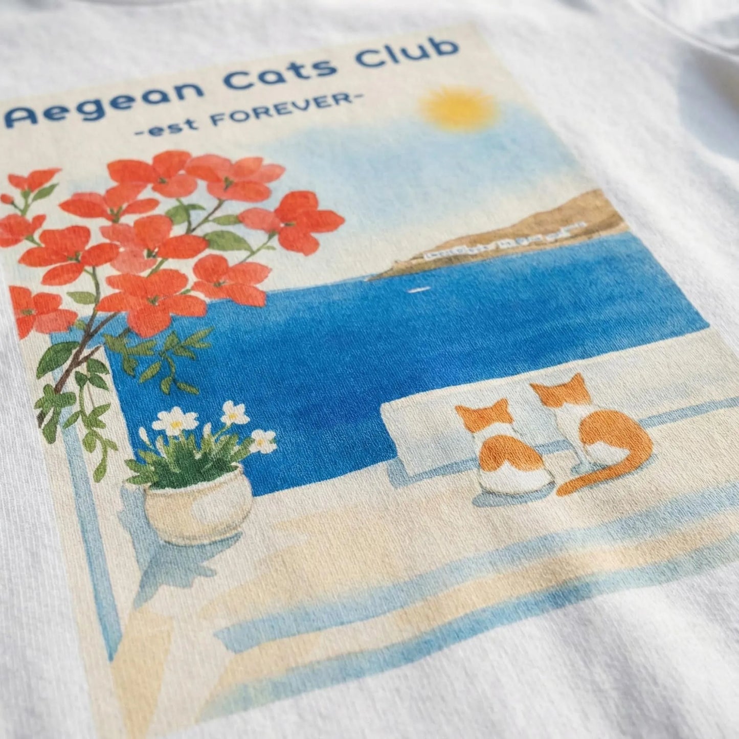 Close-up of Aegean Cats Club cat illustration printed on t-shirt