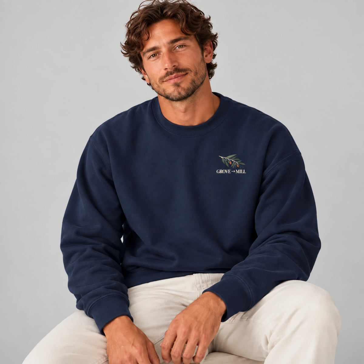 Male model wearing the True Navy Grove to Mill sweatshirt from the front, showing the small Grove to Mill olive-branch left-chest print.