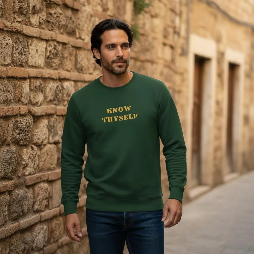 Model wearing Know Thyself Ancient Revival embroidered sweatshirt against a stone urban backdrop