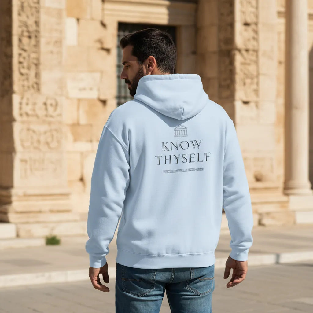 Model wearing Know Thyself Ancient Revival DTG hoodie in light blue with back print visible in urban stone setting