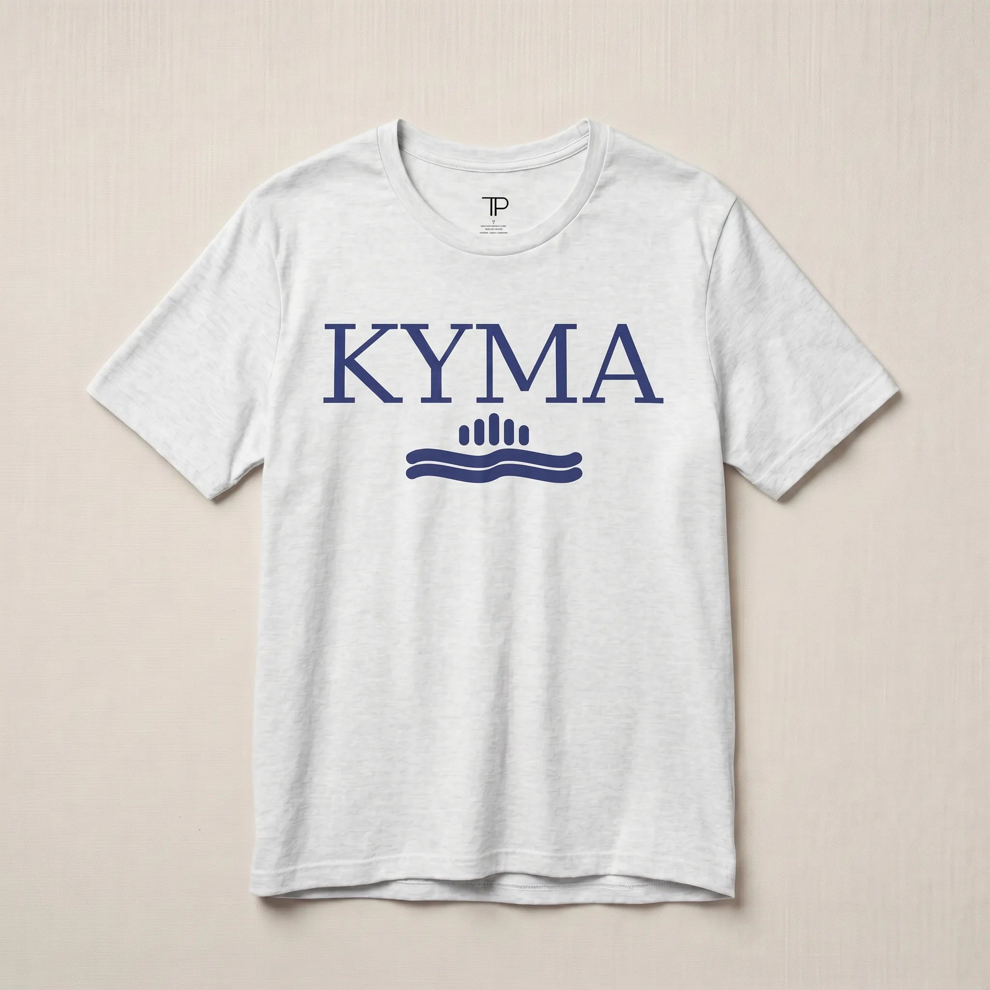 White t-shirt with 'KYMA' logo on a beige background