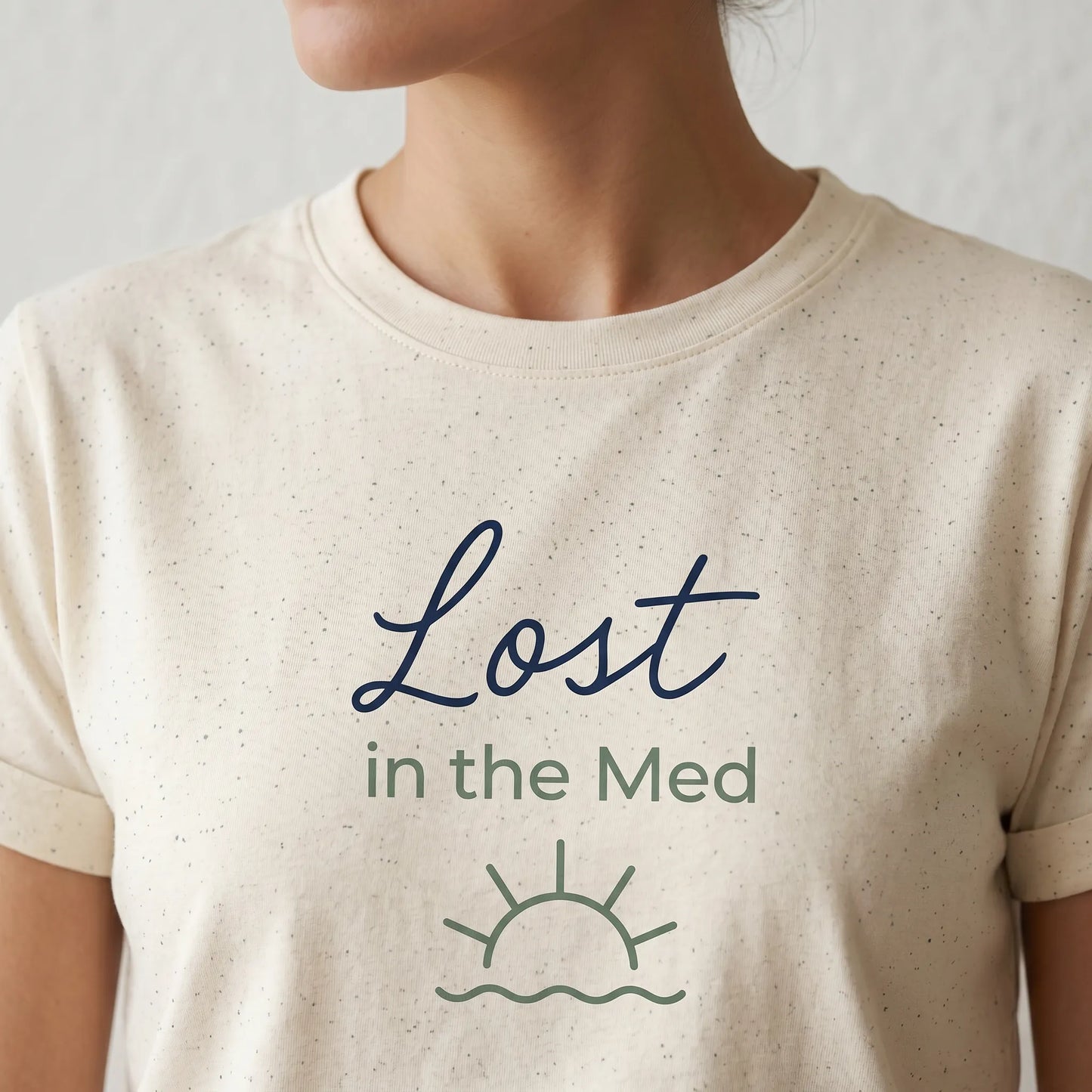 TP HERO: Beige t-shirt with 'Lost in the Med' text and sun/wave graphic on a plain background