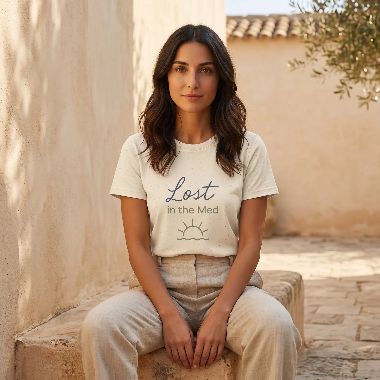 Woman wearing Lost in the Med Mediterranean T-shirt in a calm outdoor coastal setting