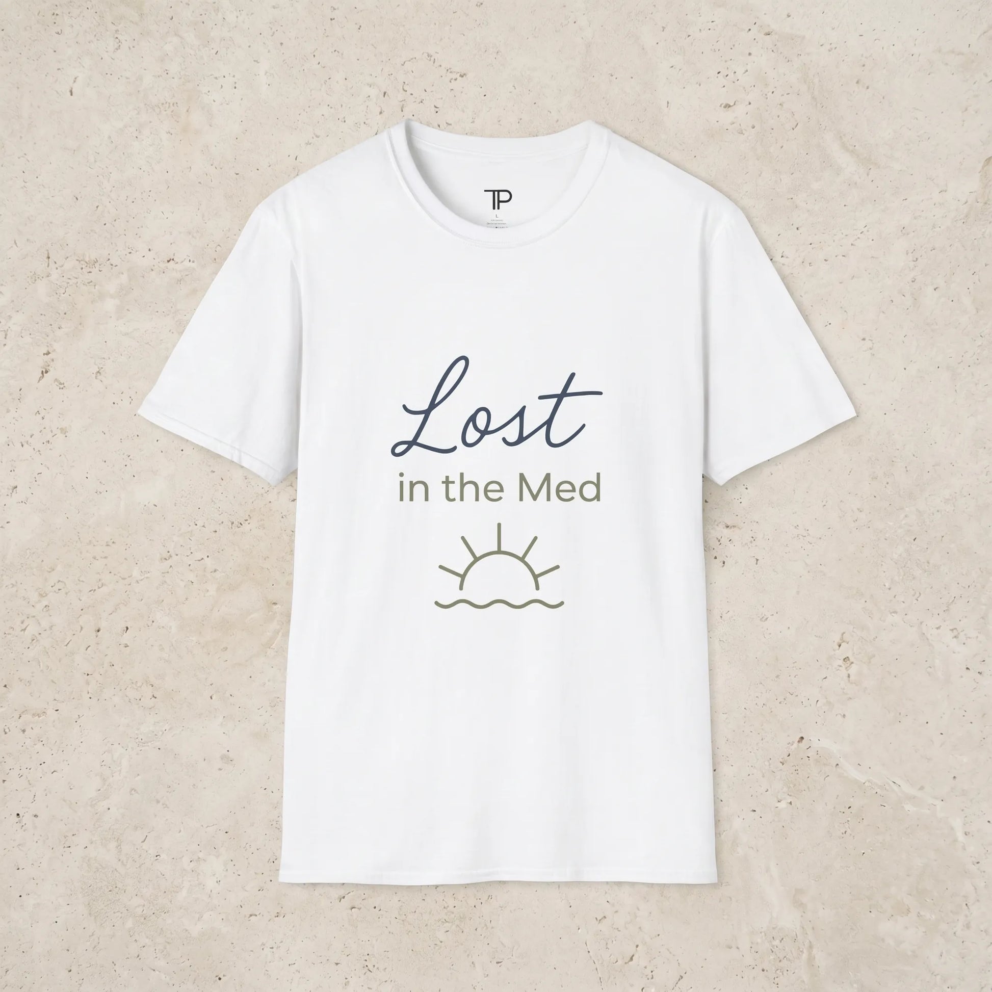 white t-shirt with 'Lost in the Med' text and sun graphic on a light beige background