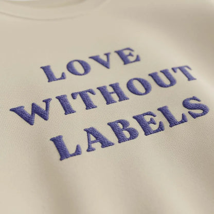 Close-up of Love Without Labels inclusive slogan embroidery on fleece sweatshirt fabric