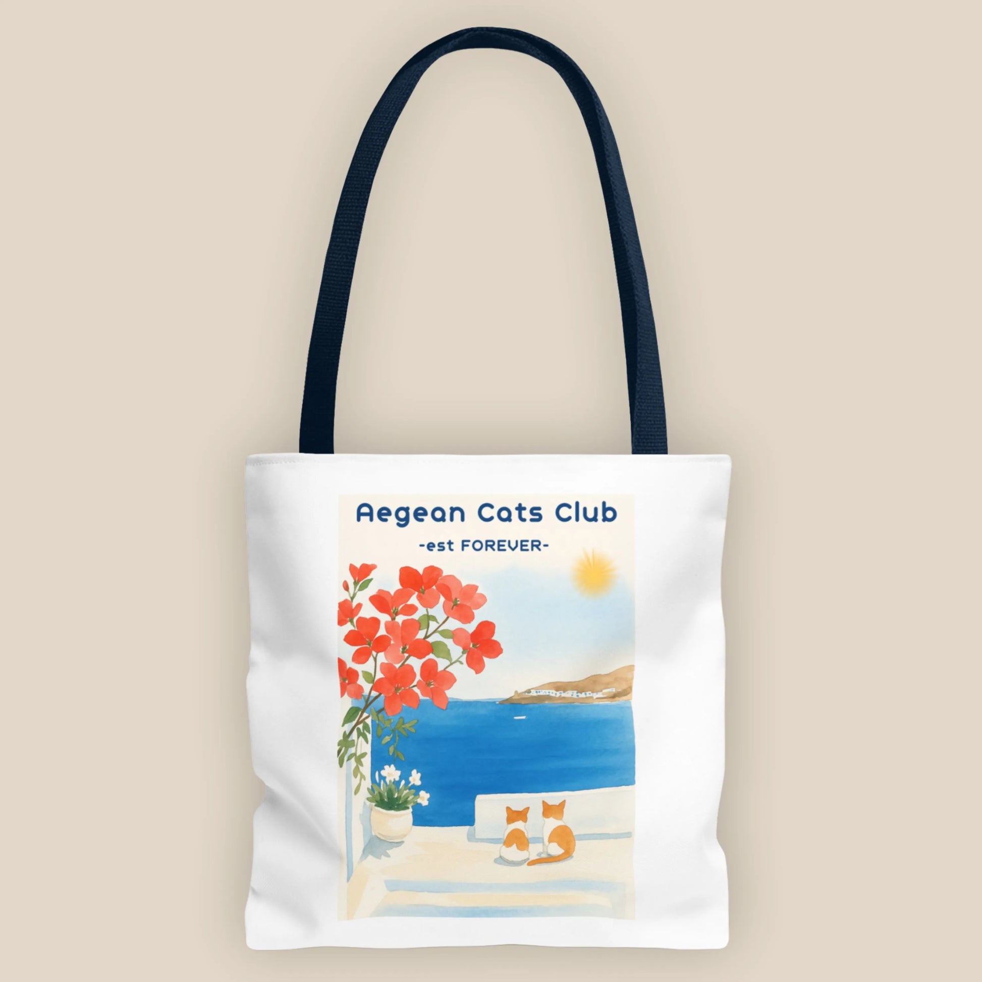 Tote bag with Aegean Cats Club design featuring a cat, flowers, and ocean view on a beige background.