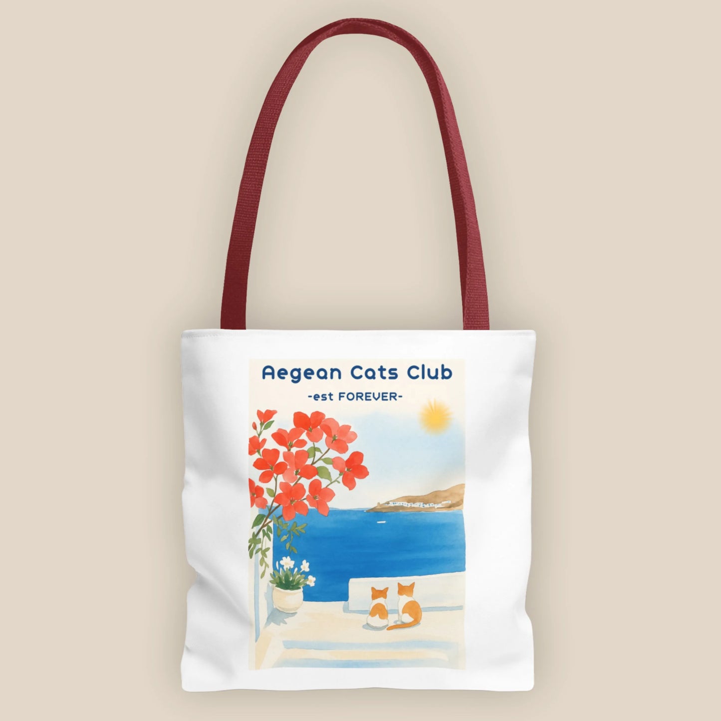 Tote bag with Aegean Cats Club design featuring a coastal scene and flowers.