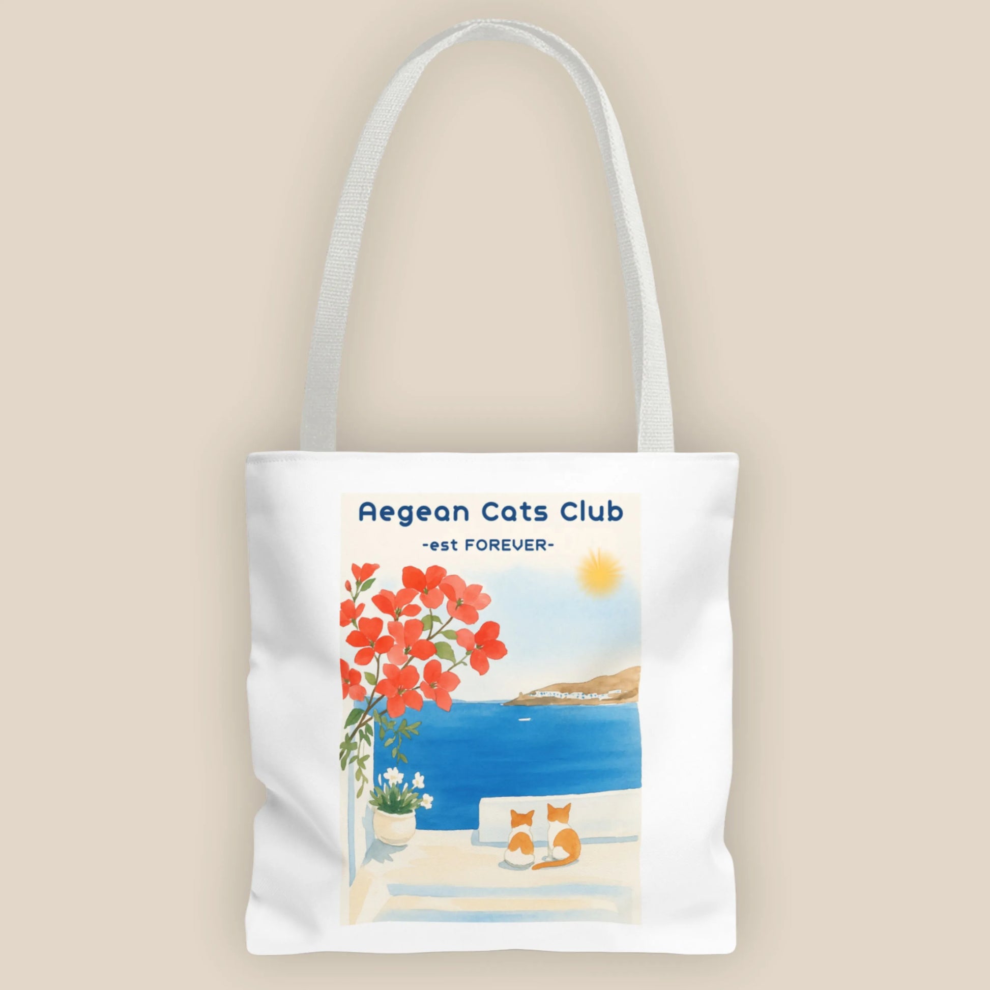 Tote bag with Aegean Cats Club design featuring a coastal scene and flowers.