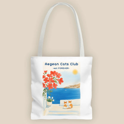 Tote bag with Aegean Cats Club design featuring a coastal scene and flowers.