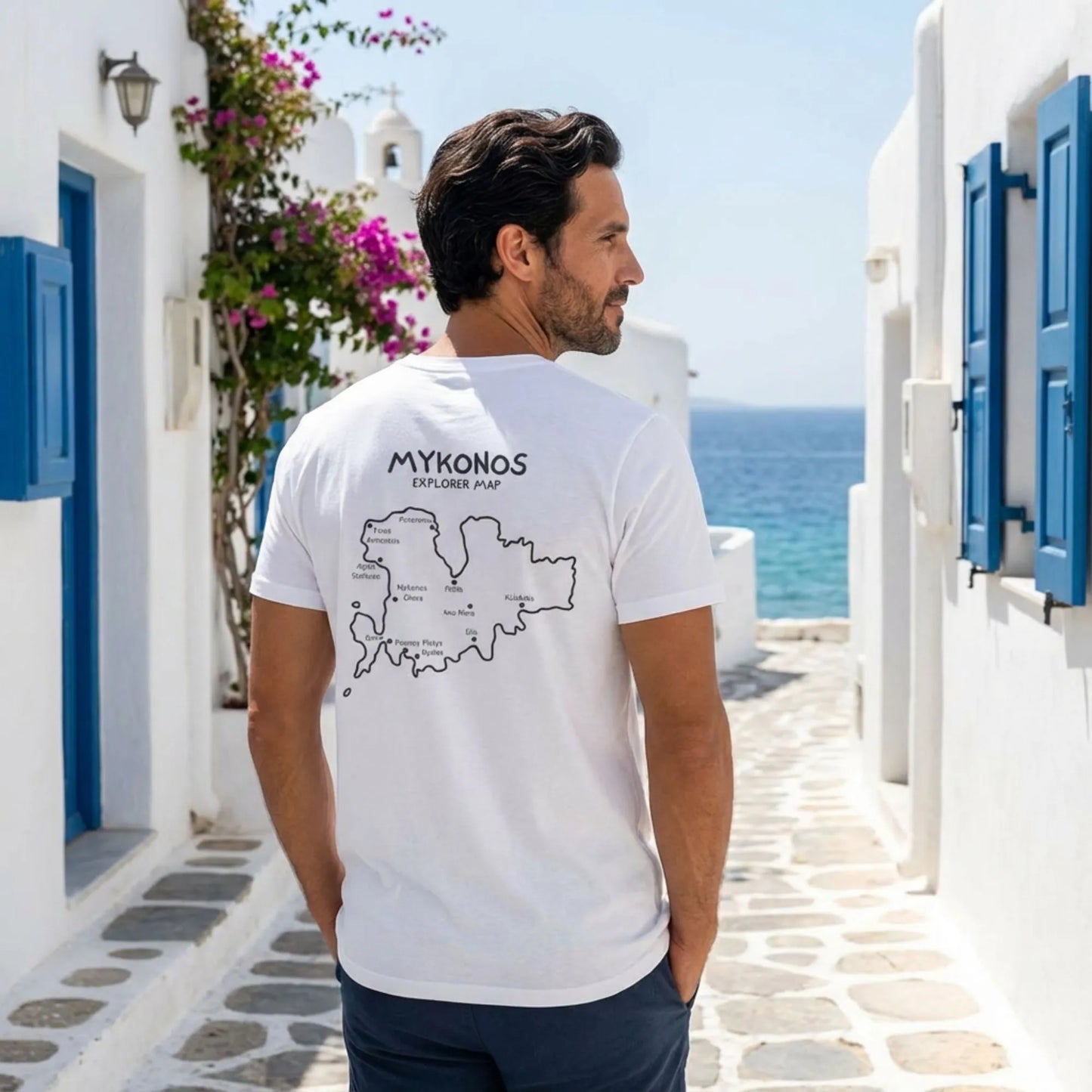 Model wearing Mykonos Island Map t-shirt walking in a Mediterranean alley
