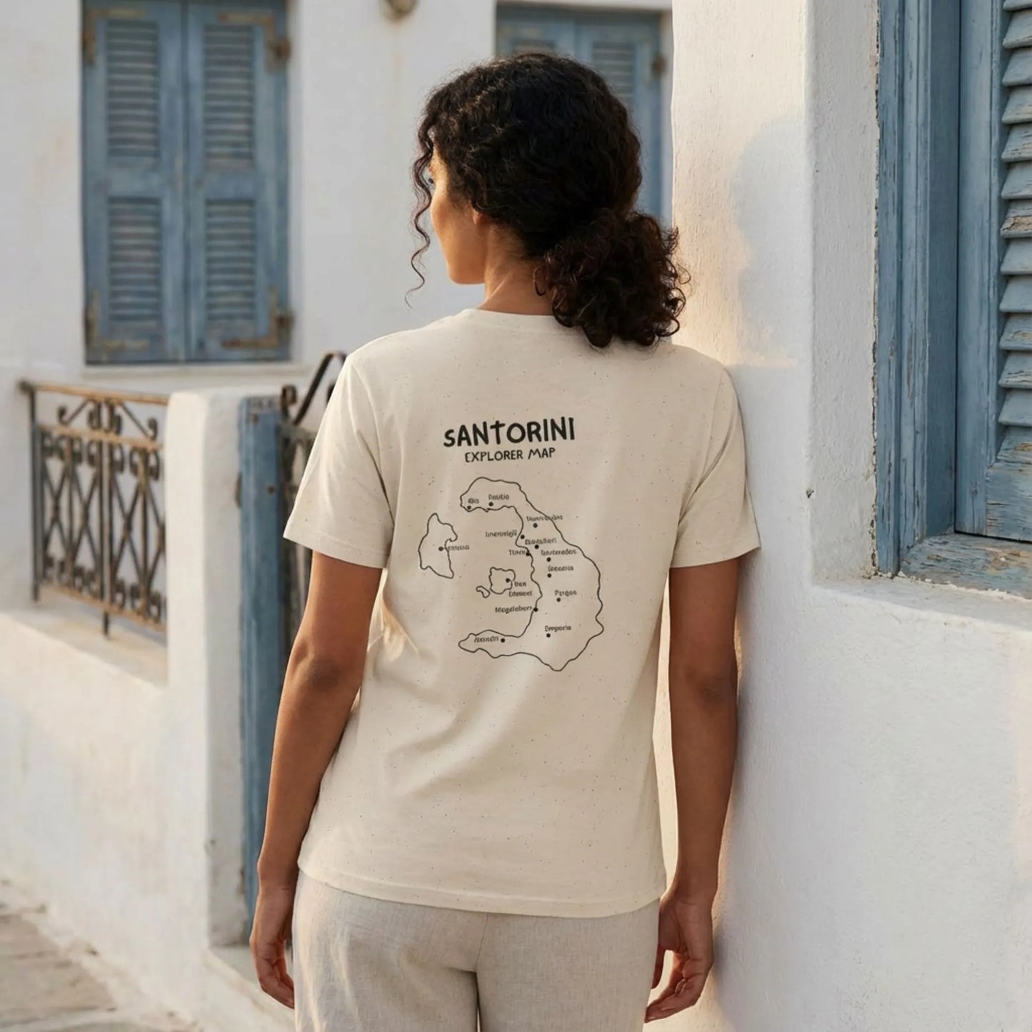 Santorini Island Map t-shirt worn by model in Cycladic whitewashed setting