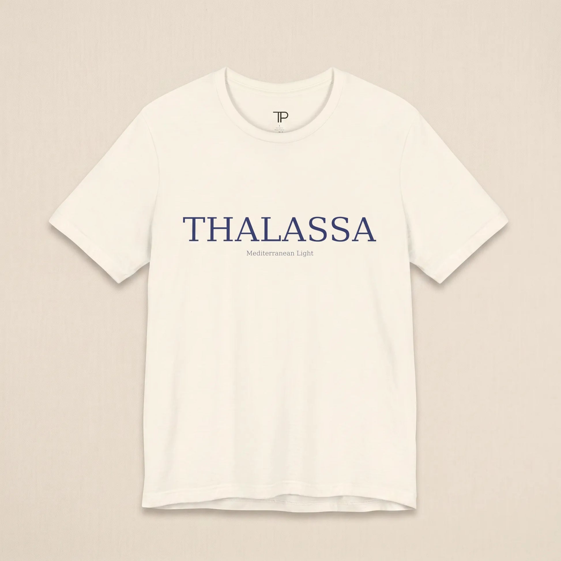 White t-shirt with 'THALASSA' text on a beige background
