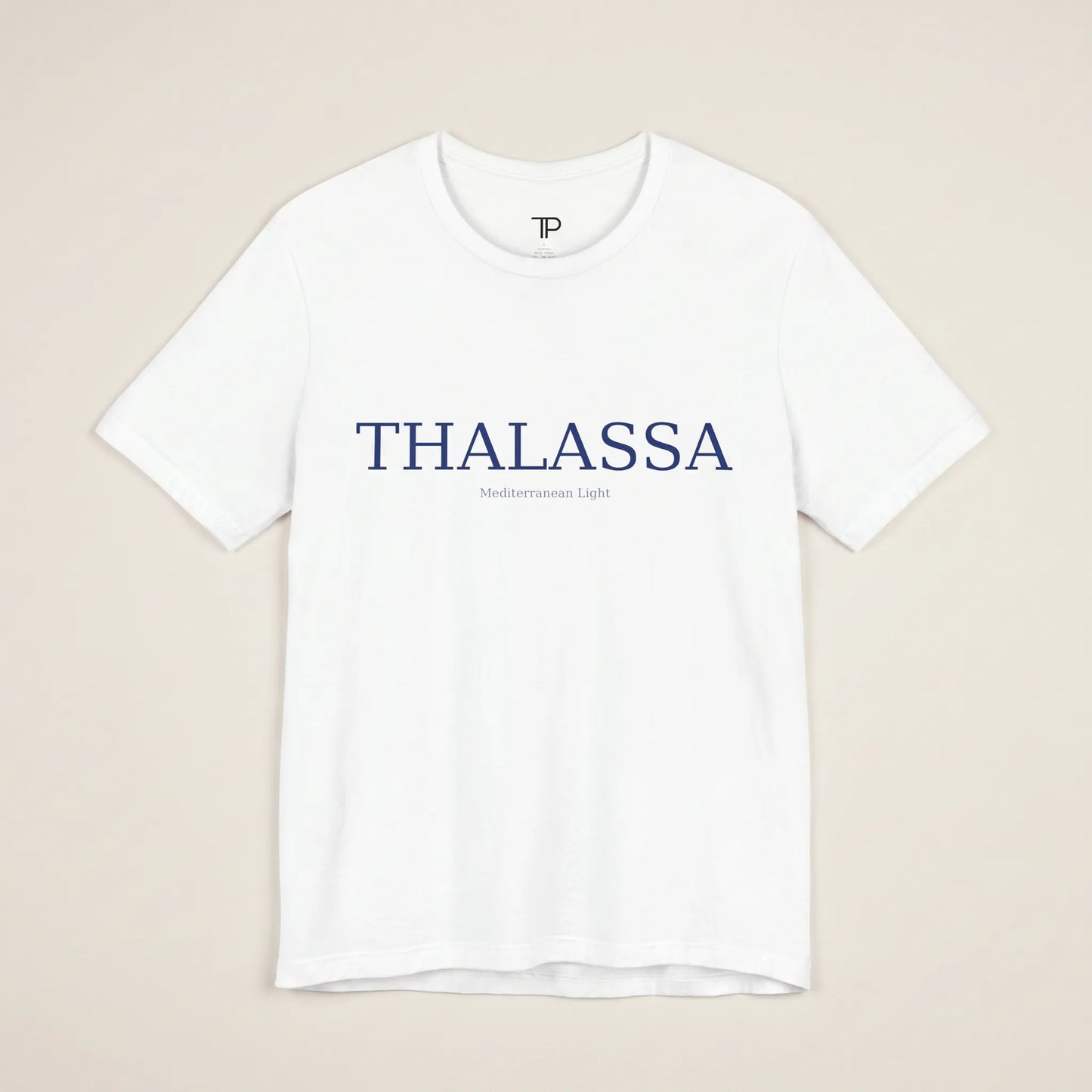 White t-shirt with 'THALASSA' text on a beige background
