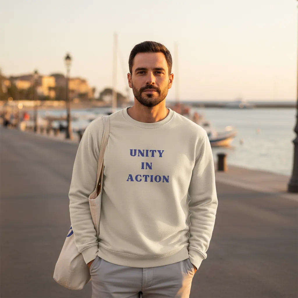 Model wearing Unity in Action embroidered hoodie during a calm Mediterranean evening walk by the sea