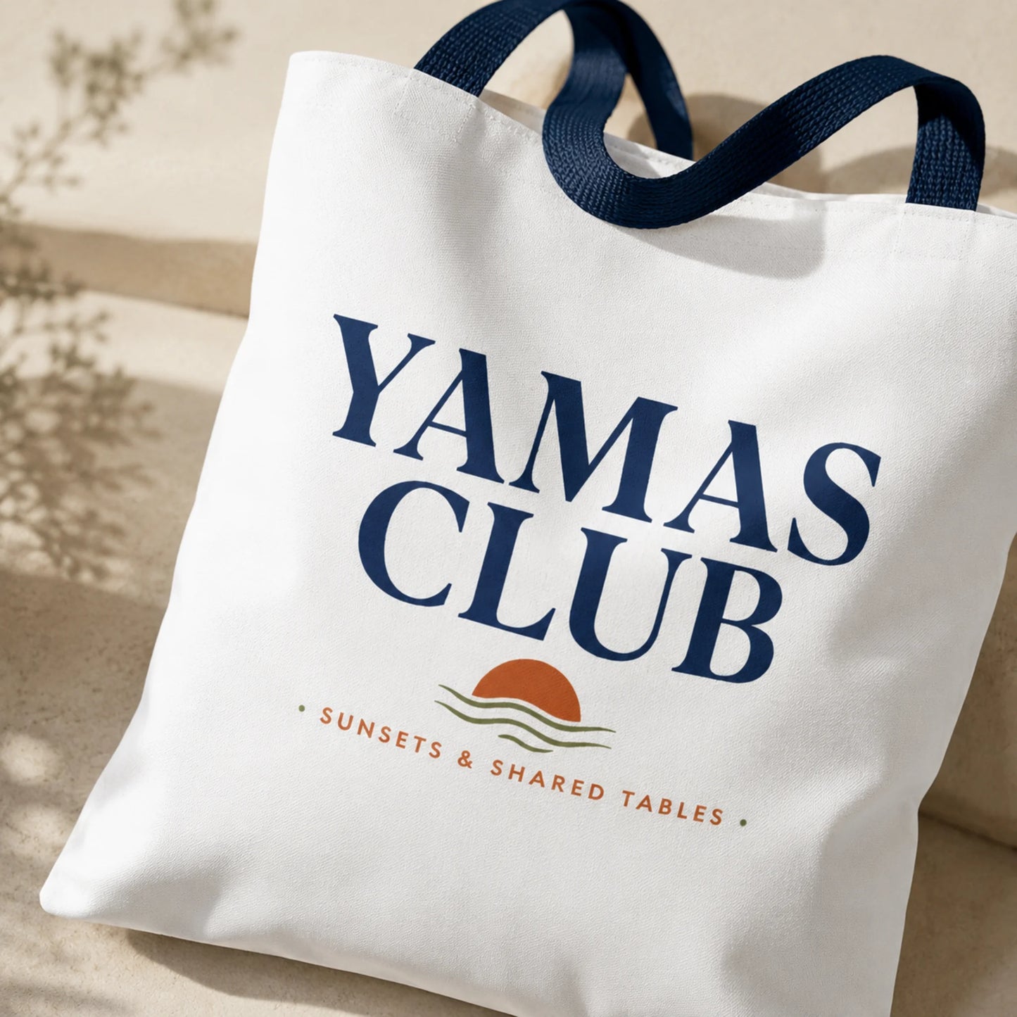 White tote bag with 'Yamas Club' text and logo on a neutral background