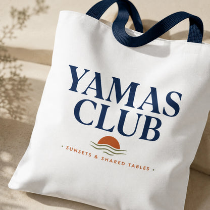 White tote bag with 'Yamas Club' text and logo on a neutral background